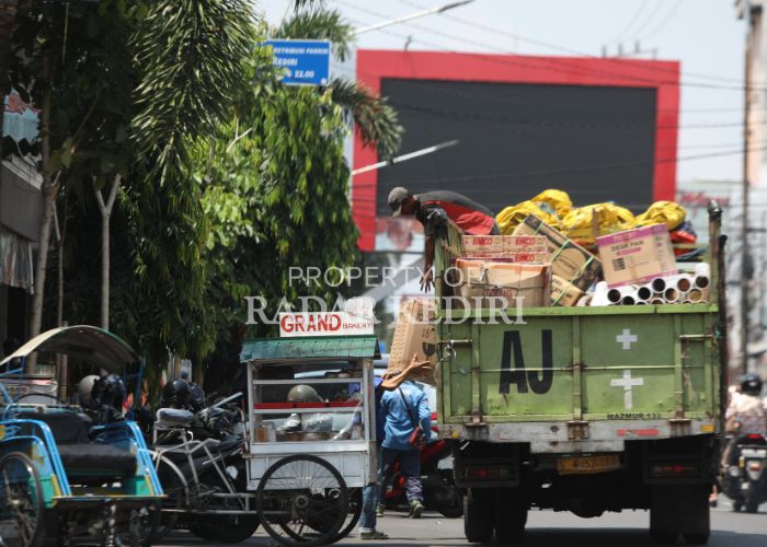 MELAMBAT: Seorang kuli angkut mengangkat kardus barang elektronik yang baru diturunkan dari truk. Dunia usaha menahan ekspansi bisnis kaitannya dengan momen pemilihan kepala daerah.