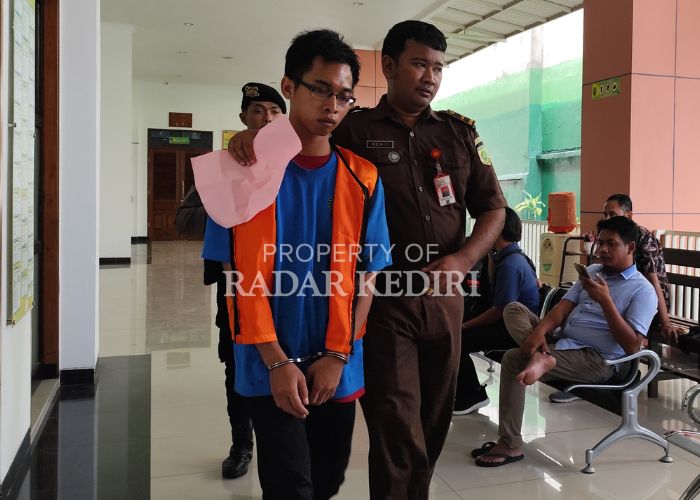 MINTA KERINGANAN: Terdakwa Fikri saat digelandang petugas kejaksaan sebelum masuk ke ruang sidang di PN Kota Kediri