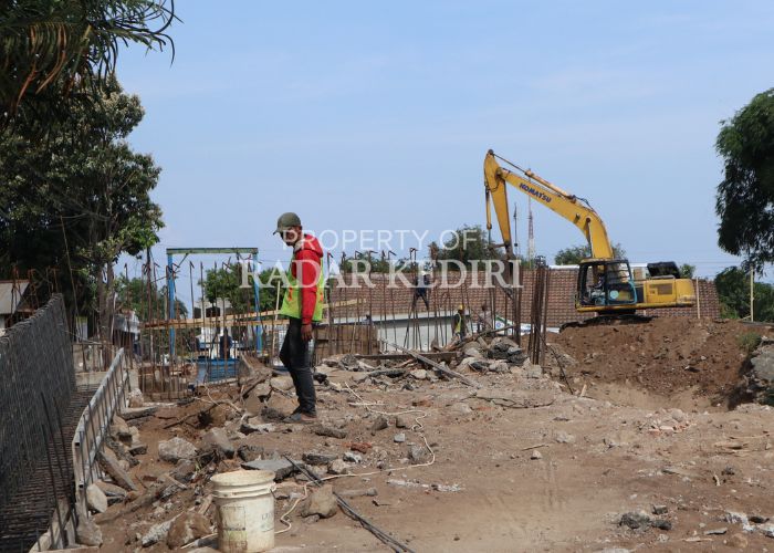 DIKEBUT: Para pekerja proyek jembatan di gang 7 Mojoroto kejar deadline. Proyek fisik jembatan ini baru selesai 50 persen.