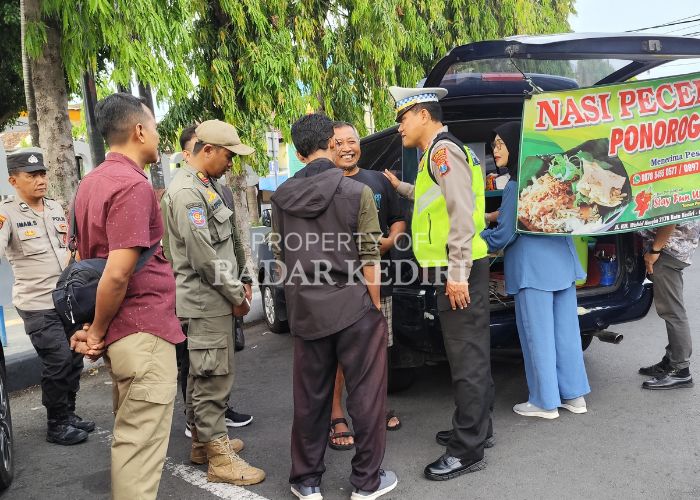 KENA TEGUR: Petugas gabungan berdialog dengan seorang pedagang di Jalan Brawijaya, Kelurahan Pakelan.