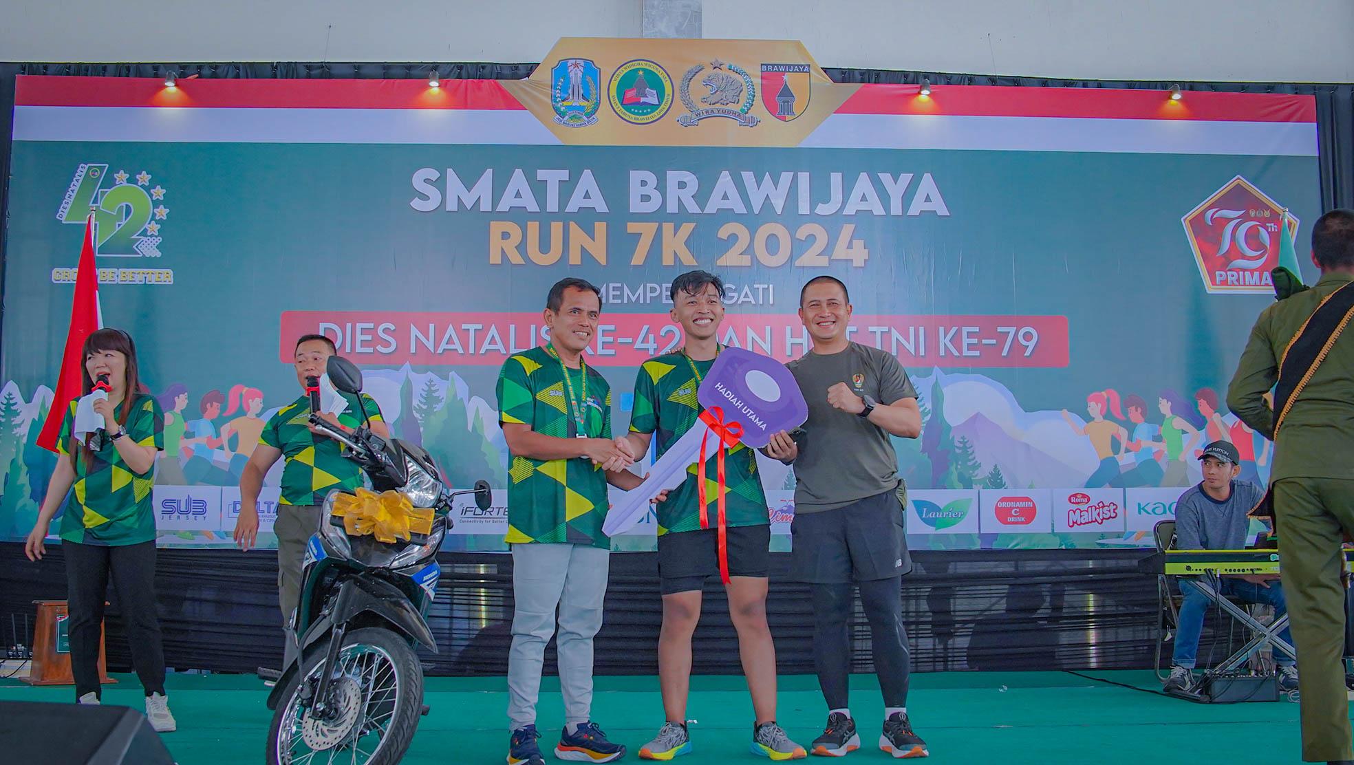 HADIAH UTAMA: Sekretaris Dinas Pendidikan Provinsi Jatim Suhartono (kiri) dan Komandan Brigif&nbsp;16 /WY&nbsp;Letkol. Inf&nbsp;Taufik&nbsp;Ismail (kanan) menyerahkan kunci sepeda motor secara simbolis.