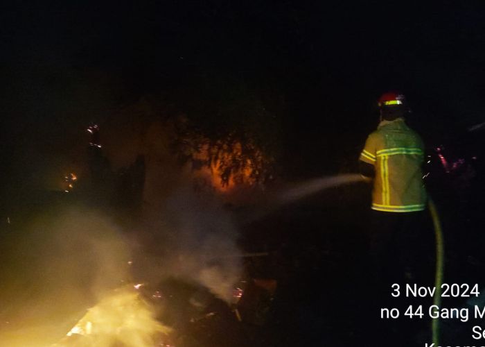 BIKIN GEMPAR: Petugas saat memadamkan api yang melalap pekarangan rumah warga di Kelurahan Semampir.