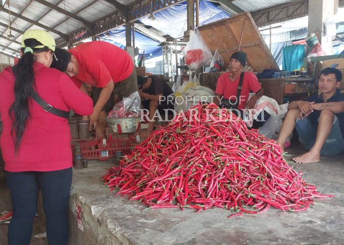 MELIMPAH: Pedagang cabai merah besar melayani pembeli di Pasar Induk Pare.