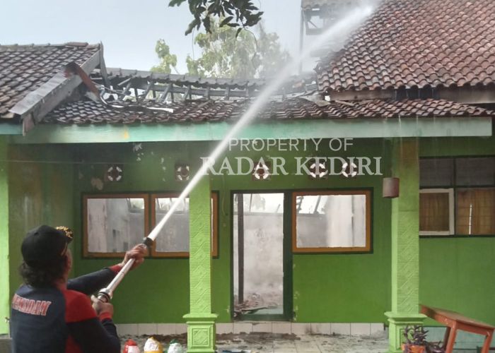 KEBAKARAN: Damkar meyemprotkan air di titik api yang sempat membara di SDN 2 Pelem Pare