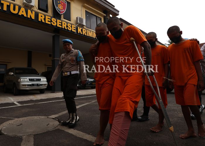 PINCANG:Tesangka perampokan minimarket berjalan menuju ruang tahanan usai rilis di Polres Kediri.
