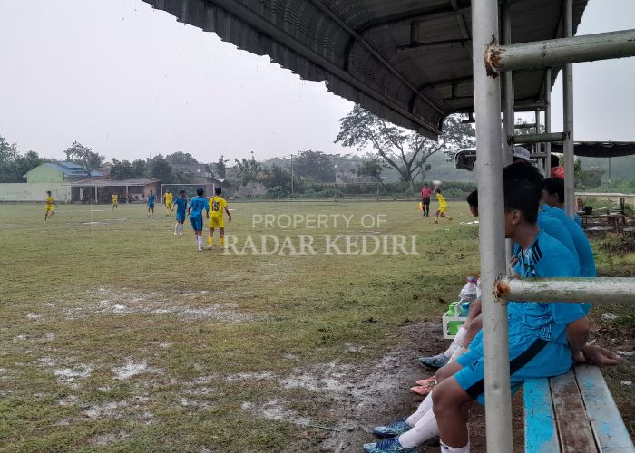 TAK PEDULI HUJAN: Pertandingan Piala Soeratin Kota Kediri U-15 yang digelar di Lapangan Kelurahan Tamanan, Kecamatan Mojoroto diwarnai hujan.