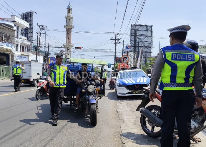 KENA TILANG: Seorang pengendara yang membawa galon dihentikan polisi karena tidak memakai helm.