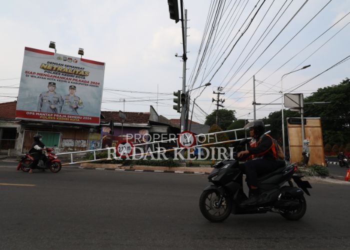 TAK BERFUNGSI: Pengendara melintas di samping portal rusak yang telah ditepikan ke pinggirkan  jalan raya.