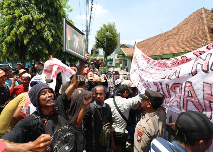 Ratusan petani Desa Satak, Kecamatan Puncu melakukan aksi demo di depan kantor Perhutani KPH Kediri Jalan Hasanudin, Kota Kediri dengan membawa foto Wapres Gibran Rakabuming Raka. Mereka menuntut agar