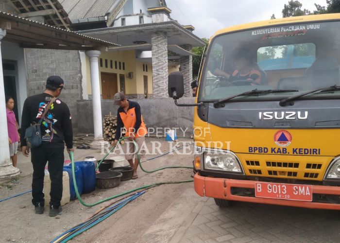 DROPPING: Petugas BPBD menuangkan air bersih dari tangki mobil ke ember milik warga Desa Sepawon, Plosoklaten.