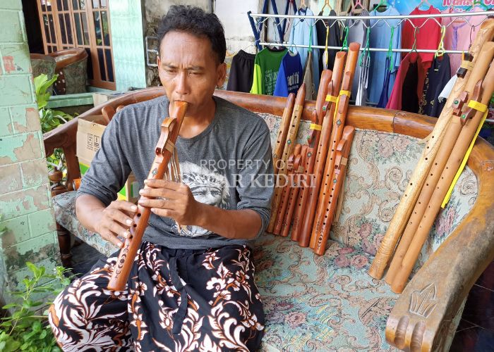 Sugiarto memainkan seruling kayu buatannya yang diminati oleh masyarakat di berbagai belahan dunia.