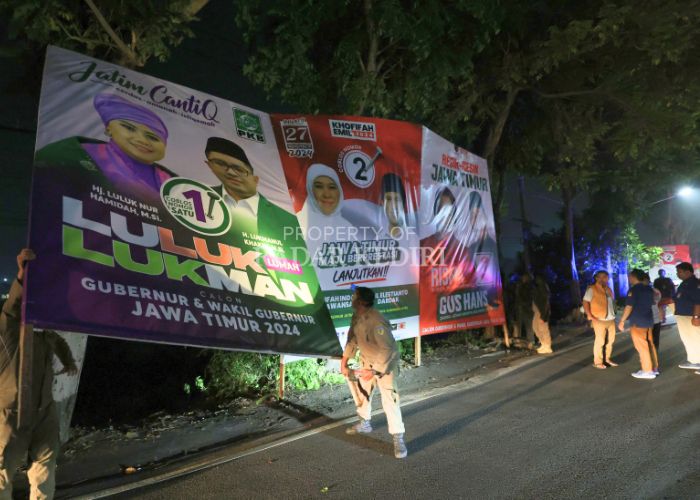 Tim gabungan melepas sejumlah banner kampanye pasangan calon gubernur dan pasangan calon bupati di Jl Erlangga, Desa Sukorejo, Ngasem dini hari kemarin.