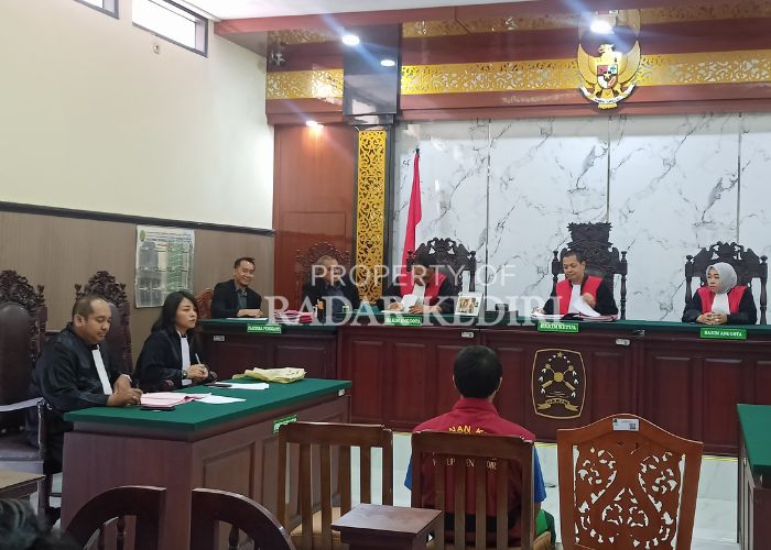 SIDANG PERDANA: Terdakwa Nurohmad duduk di kursi pesakitan sebelum sidang dimulai di ruang Cakra PN Kabupaten Kediri.