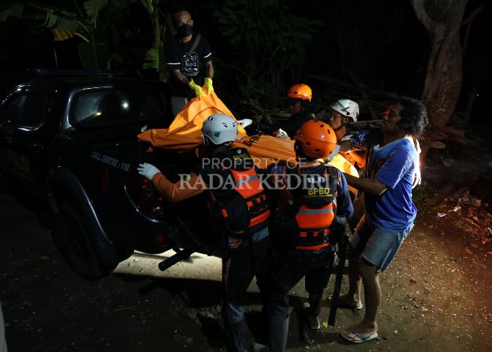 MISTERIUS: Jasad perempuan tanpa identitas dinaikkan ke atas mobil polisi oleh anggota BPBD Kabupaten Kediri.