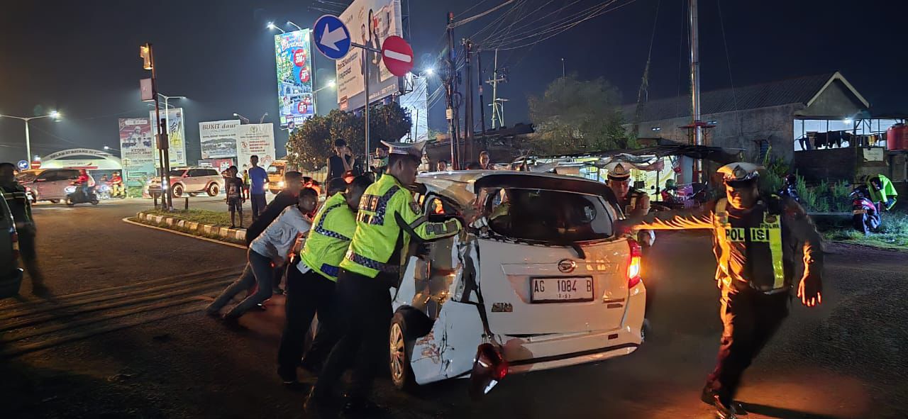 RINGSEK: Petugas kepolisian dan warga berusaha mengamankan mobil Daihatsu Sigra usai tertemper KA Dhoho di Mengkreng, Kediri.