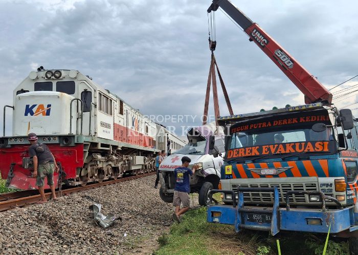 RINGSEK: Mobil ambulance milik RSUD Gambiran Kediri diderek truk evakuasi setelah disambar KA Matarmaja di Desa Nyawangan, Kras pada Rabu (4/12).