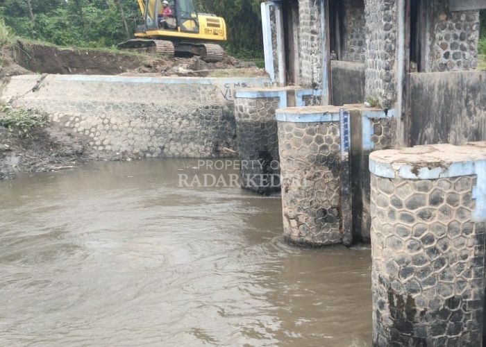 TERGERUS: Seorang pekerja sedang menyelesaikan perbaikan pelengsengan Sungai Serinjing.