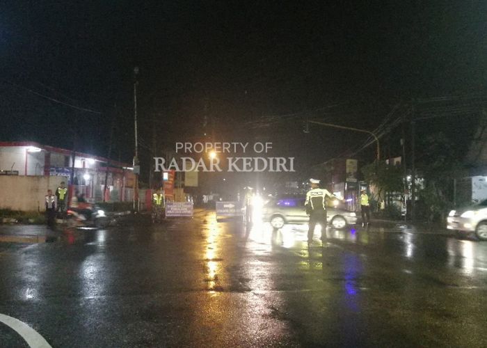 DIALIHKAN: Polisi mengatur lalu lintas di Perempatan Papar pada Selasa (24/12) malam.