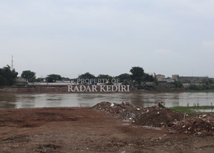 DIKEBUT: Pekerja melakukan pengurukan di tepi Sungai Brantas untuk membangun jembatan tol Kediri-Tulungagung.
