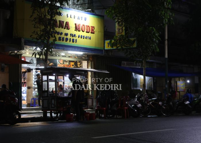 MENGGANGGU: Seorang pedagang kaki lima buka lapak sebelum waktunya saat malam hari di depan toko Jalan Dhoho.
