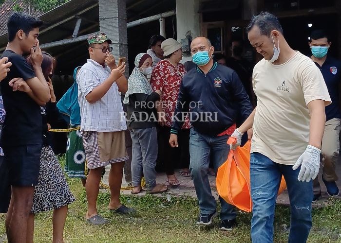 MISTERIUS: Petugas kepolisian membawa keluar kantong jenazah perempuan yang tewas di kamar rumahnya.