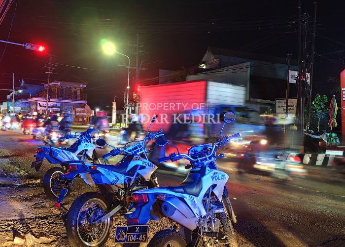 PENGAWALAN KETAT: Polisi menjaga rombongan pesilat yang melintas di Kota Kediri.