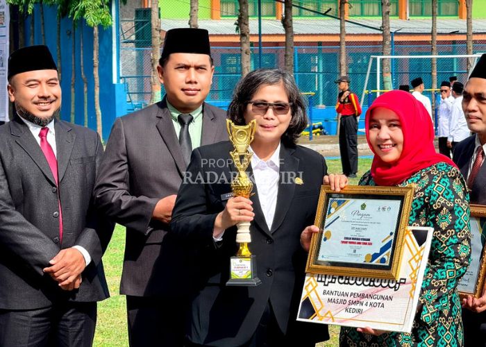 BERPRESTASI: Kepala SMPN 4 Kota Kediri, Yayuk Cahyaningsih (kanan) menerima penghargaan Juara 1 Sekolah Moderasi Beragama se-Jatim