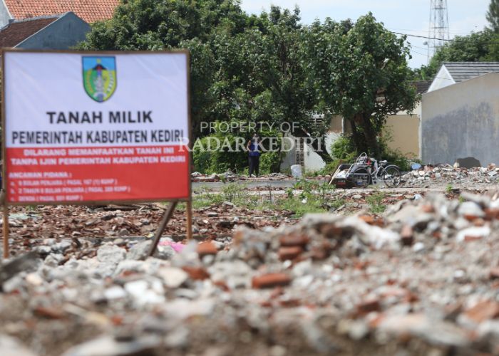 RATA DENGAN TANAH: Seorang tukang becak sedang bersantai di dekat puing-puing pasar Ngadiluwih.