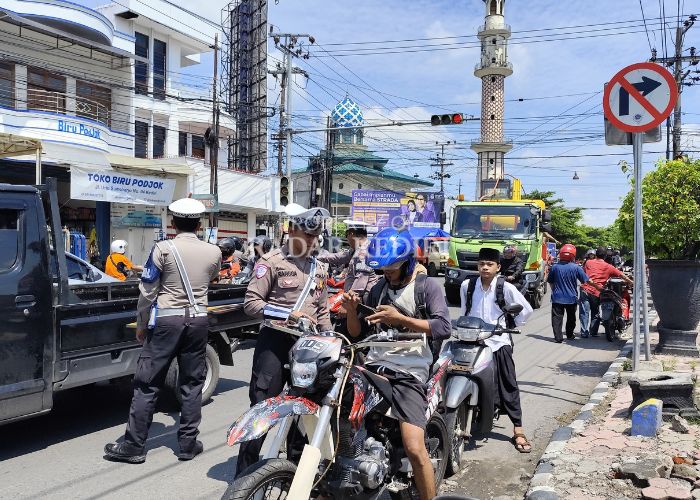 KETAT: Polisi memeriksa surat-surat kendaraan pengendara bermotor yang masuk ke Kota Kediri.