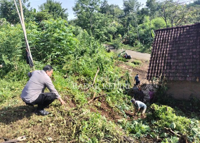 AMBROL: Anggota Polsek Mojo menunjukkan salah satu titik lokasi longsosr yang menimpa rumah warga.
