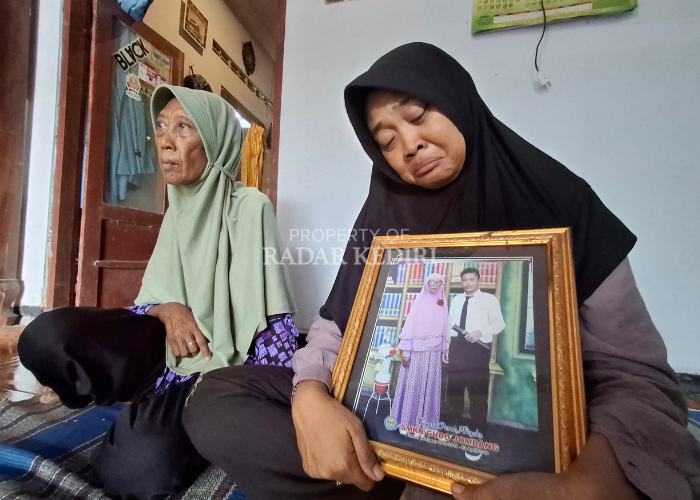 BERDUKA: Widyawati, 43, kakak Septian Adi Ferdiansyah menunjukkan foto semasa hidup adiknya ditemani Supiyah, sang ibu, kemarin.