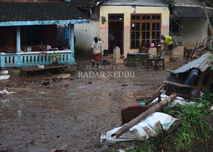 BANJIR: Warga Desa Tiron membersihkan sisa-sisa kebanjiran.