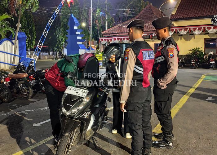 KENA RAZIA: Pengendara membuka jok motor di depan dua anggota polisi.