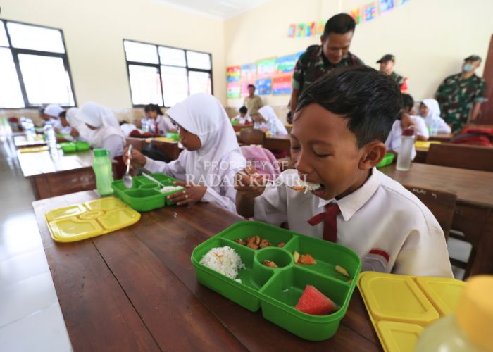 PERDANA: Sejumlah siswa SDN Bangsongan 1 Kayenkidul menyantap menu makan bergizi gratis hari pertama kemarin yang dipantau oleh TNI.