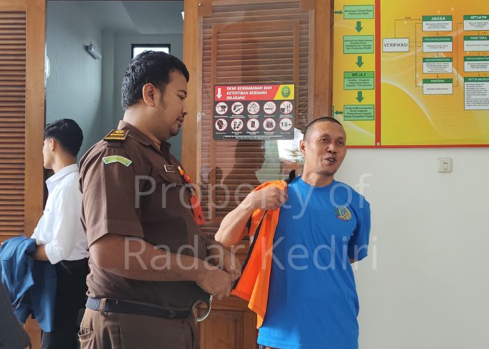 PIKIR-PIKIR: Terdakwa Masruchan tersenyum usai menjalani sidang di Pengadilan Negeri Kota Kediri.