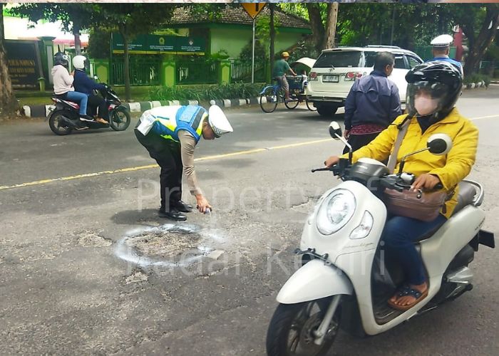 BERI TANDA: Polisi melingkari lubang menggunakan cat pilox warna putih