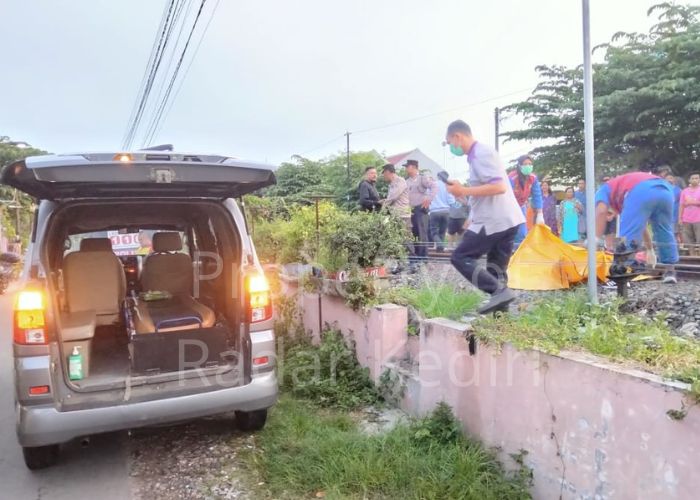 TEWAS MENGENASKAN: Petugas membawa jasad korban kecelakaan kereta api di Kelurahan Setonopande, Kota Kediri.