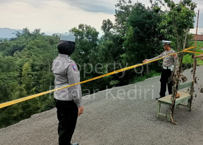 BERBAHAYA: Polisi mengecek lokasi longsor di jalan menuju Wisata Air Terjun Dolo.