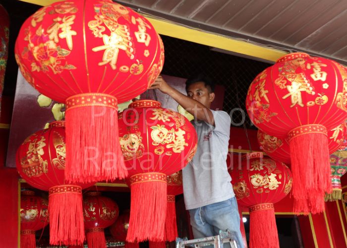 SAMBUT TAHUN BARU: Seorang pekerja Klenteng Tjoe Hwie Kiong memasang lampion untuk menyambut Imlek akhir pekan nanti.