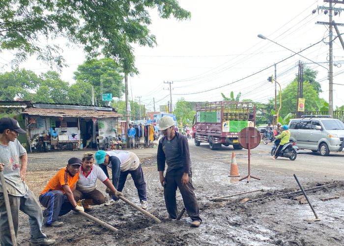 GOTONG ROYONG: Pekerja PG Meritjan membongkar rel yang menyebabkan jalan rusak.