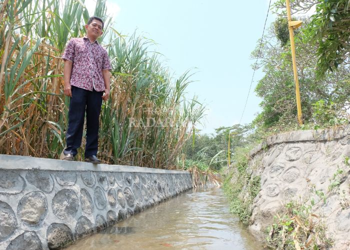Kades Blimbing Agus Dwi Waluyo mengecek saluran irigasi.