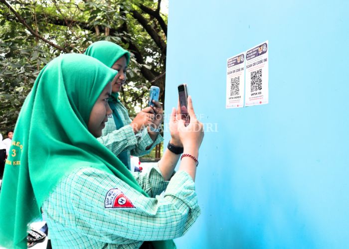 DIGITAL: Sejumlah pelajar memindai kode batang yang tertempel di dinding Pojok Baca Digital di Hutan Joyoboyo untuk bisa mengakses buku koleksi Perpustakaan Nasional kemarin.