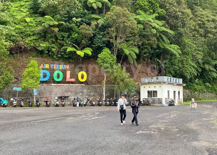 AIR TERJUN DOLO: Pengunjung berjalan di area parkir saat libur panjang.
