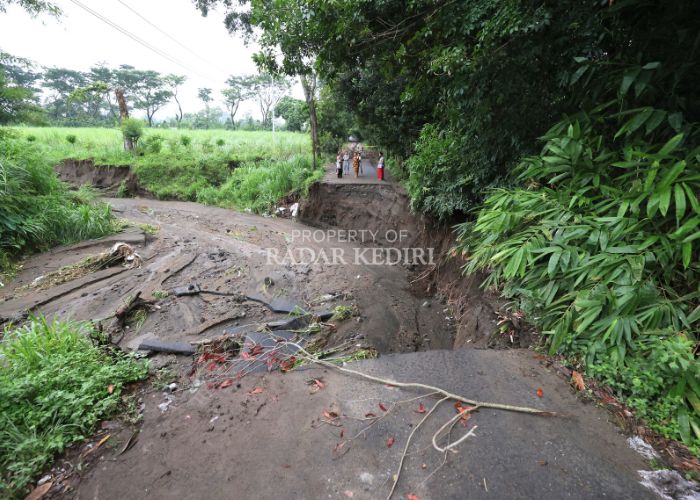 TERISOLASI: Sejumlah warga mengecek kondisi jalan Desa Sepawon, Plosoklaten yang ambrol sepanjang sekitar 20 meter tergerus air bah Rabu (29/1) sore lalu.