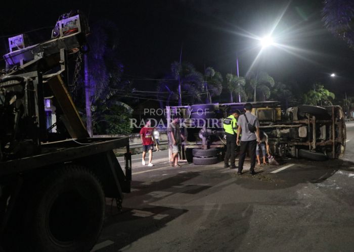 TERGULING: Petugas kepolisian mengatur lalu lintas imbas truk terguling di Jalan Sultan Iskandar Muda Semampir, Kota Kediri kemarin petang.