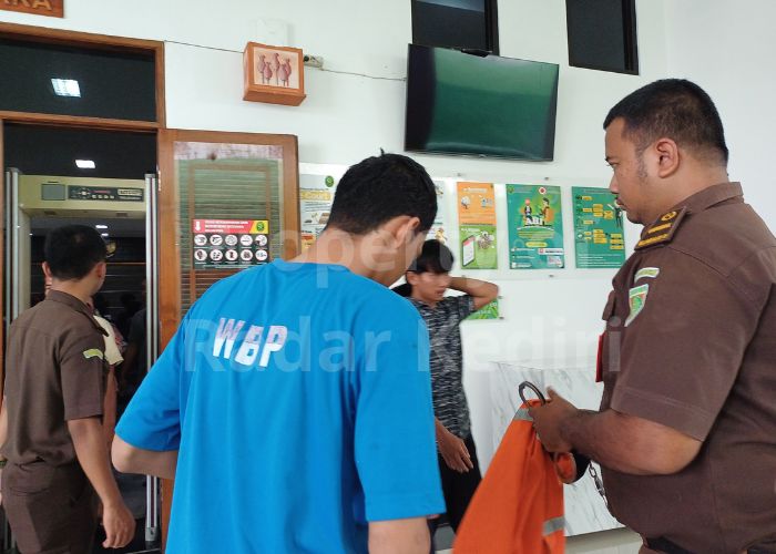 MINTA DAMAI: Seorang terdakwa pesilat yang baru saja selesai menjalani sidang mengenakan rompi oranye.