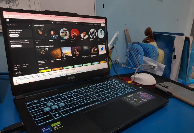 Laptop dengan tampilan Aplikasi Spotify.