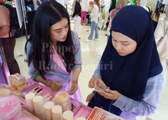 MEMBURU DISKON: Seorang pengunjung mencari produk cuhion di Kediri Beauty Fest 2025.