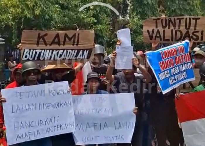 DEMO LMDH: Peserta aksi membentangkan poster saat menyampaikan tututan ke Perhutani.