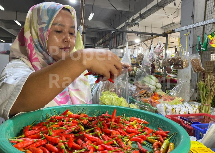 HARGA ANJLOK: Pedagang pasar di Setonobetek Kota Kediri memasukan cabai rawit ke dalam plastik.